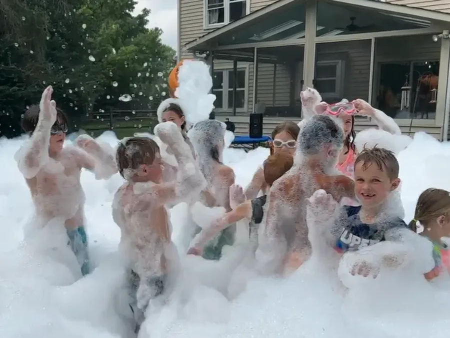 Kids playing in the foam during a backyard birthday party