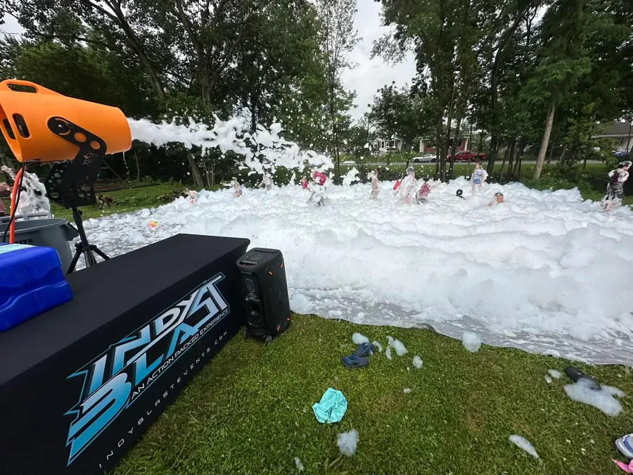 A pool of foam covering the yard during a daytime foam party