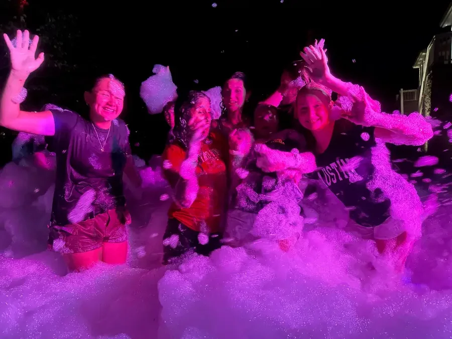 Pink glow lighting during a Night Glow foam party