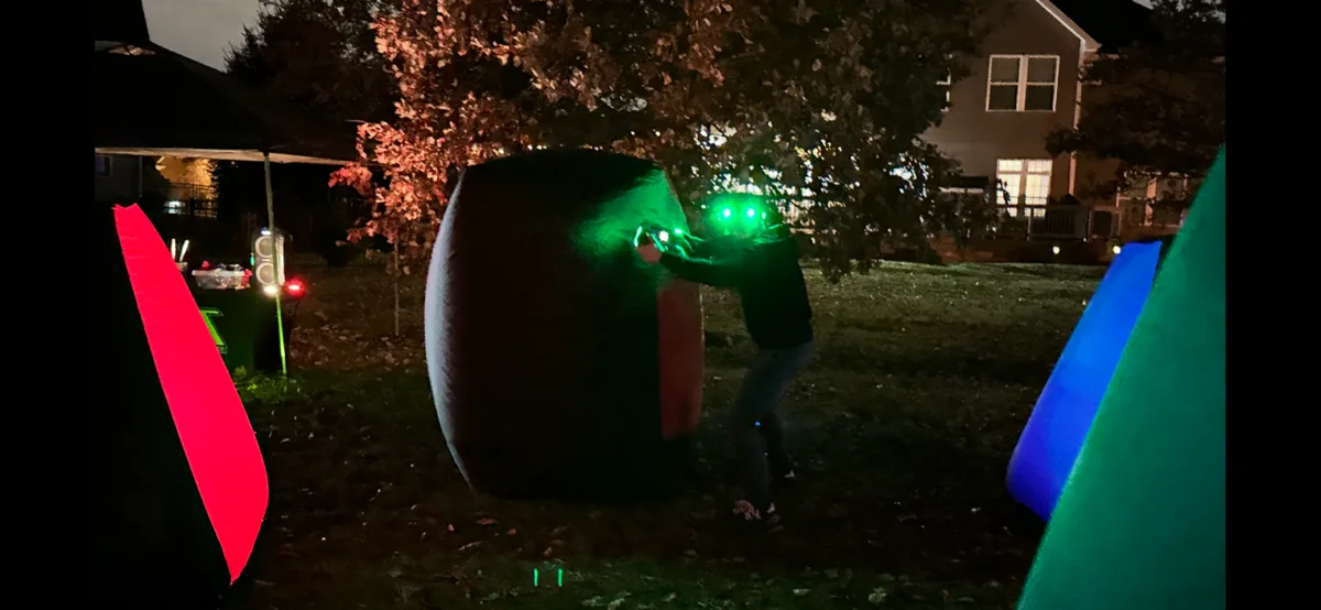 Kids playing glow laser tag at night during a birthday event