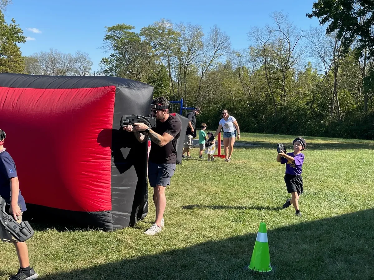 Parents playing alongside kids during a laser tag birthday mission