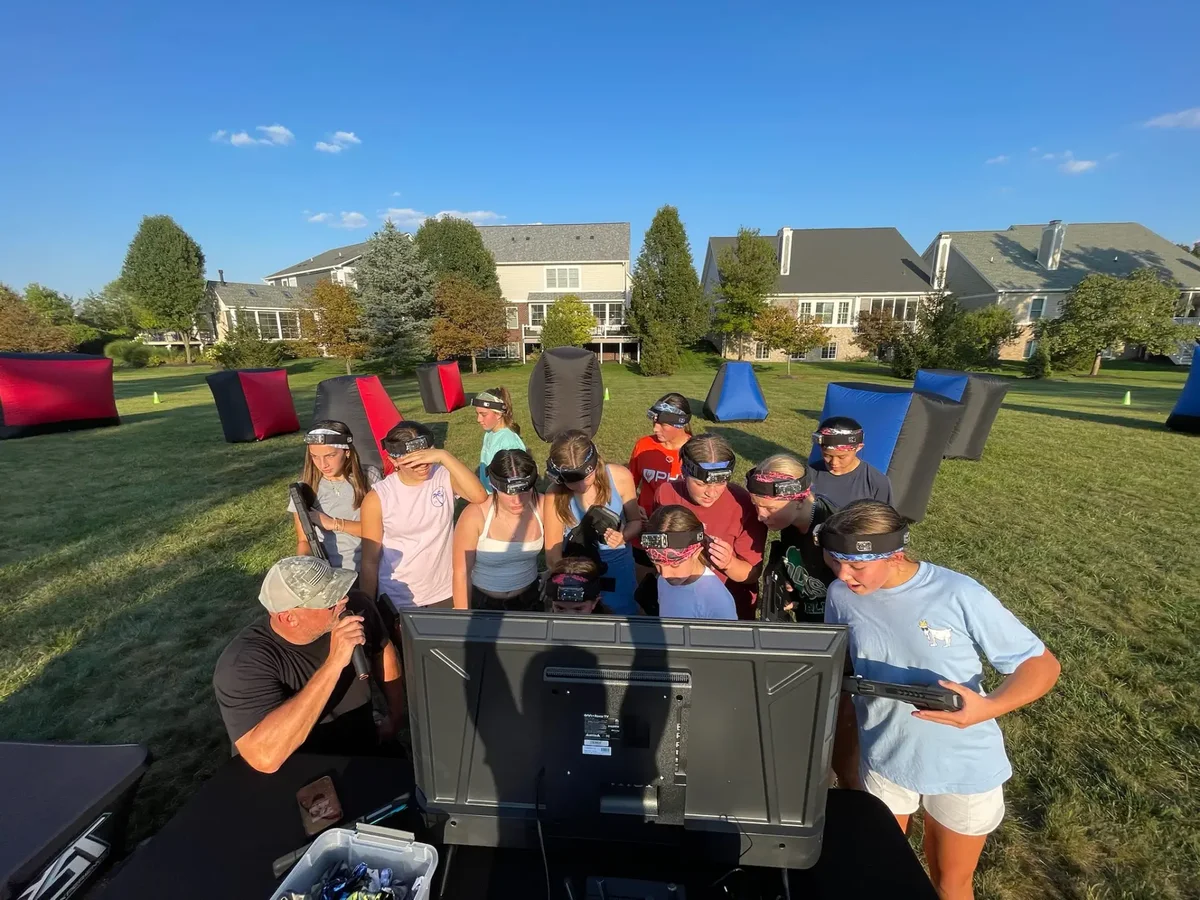 Kids checking live game scores during a birthday laser tag event