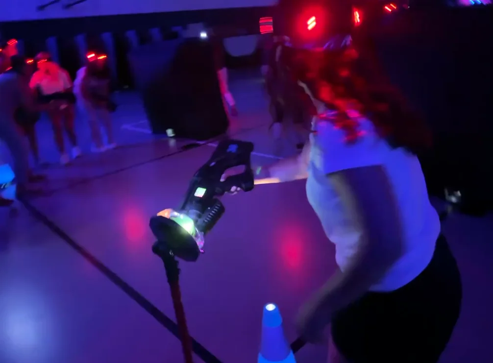 Player reactivating her blaster at a respawn station during a glow laser tag match