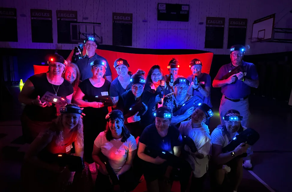 Corporate team building group photo with headlamps after a glow laser tag event