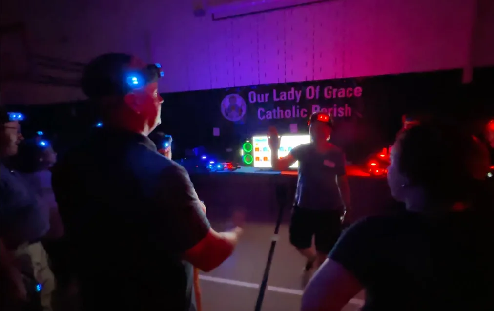 Game coach briefing a group with headlamps before a community laser tag event