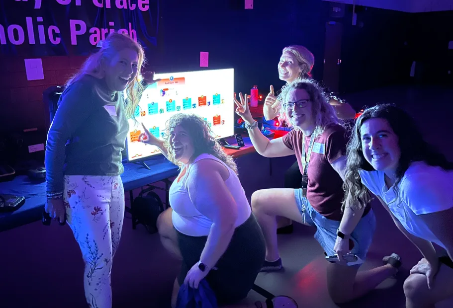 Group celebrating around the live scoreboard after a community laser tag match