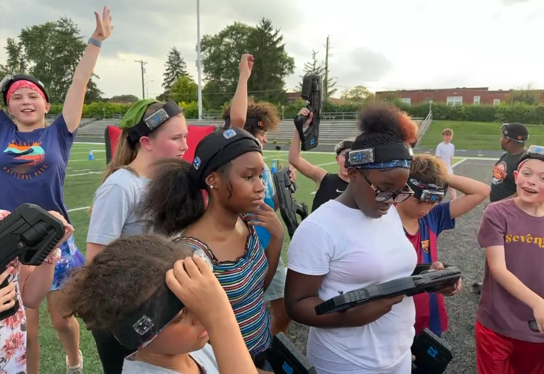 Students hyping up with hands raised before a laser tag mission at Broad Ripple Middle School