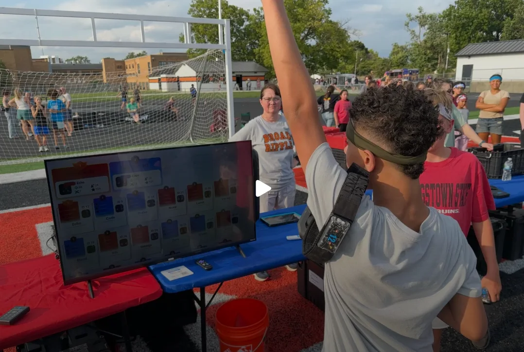 Student celebrating in front of the live leaderboard screen at a Broad Ripple Middle School laser tag event