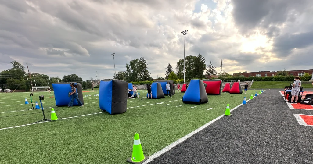 Full laser tag bunker arena set up on the football turf field under a dramatic evening sky at Broad Ripple Middle School