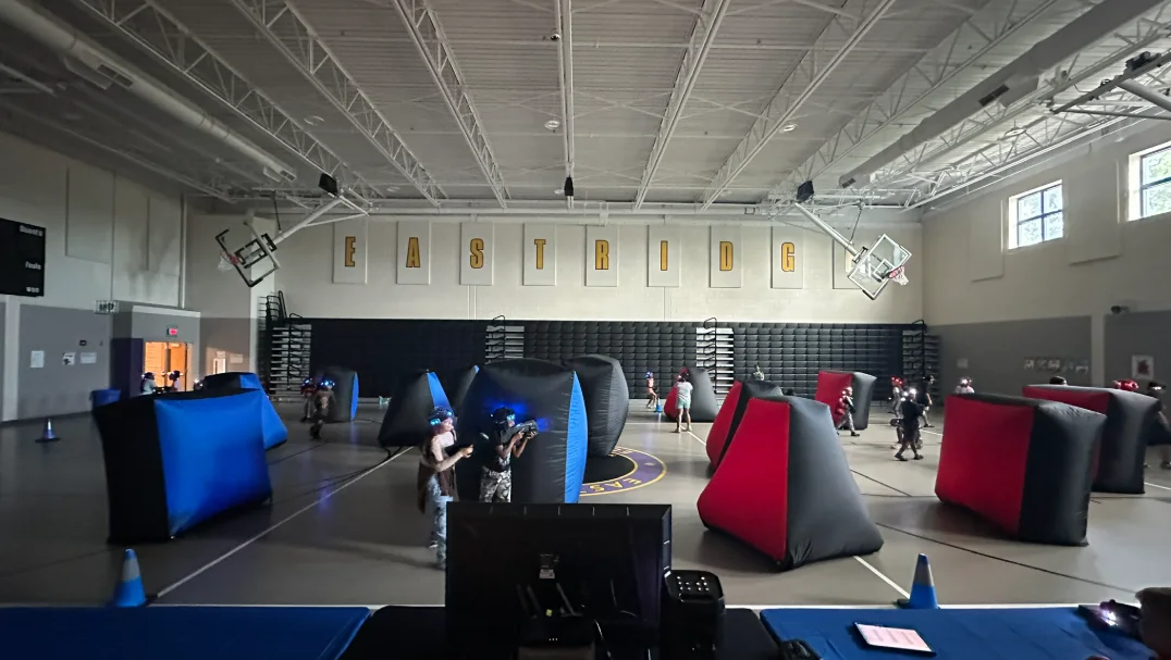 Blue and red inflatable laser tag bunkers set up in the Eastridge Elementary gymnasium
