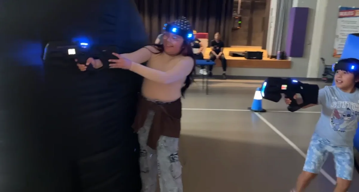 Large group of Eastridge Elementary students posing with laser tag blasters after their battles