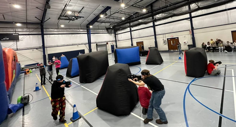 Full laser tag battlefield set up in a school gym during a middle school PTO fundraiser night