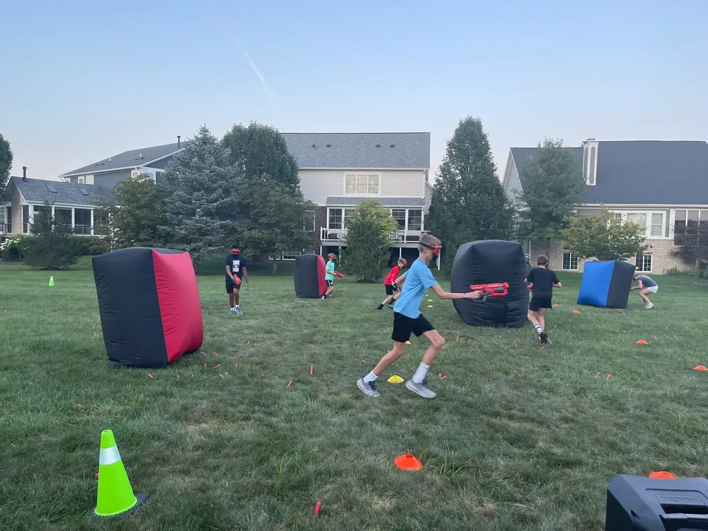 Kids running and firing Nerf blasters during a high-energy team battle