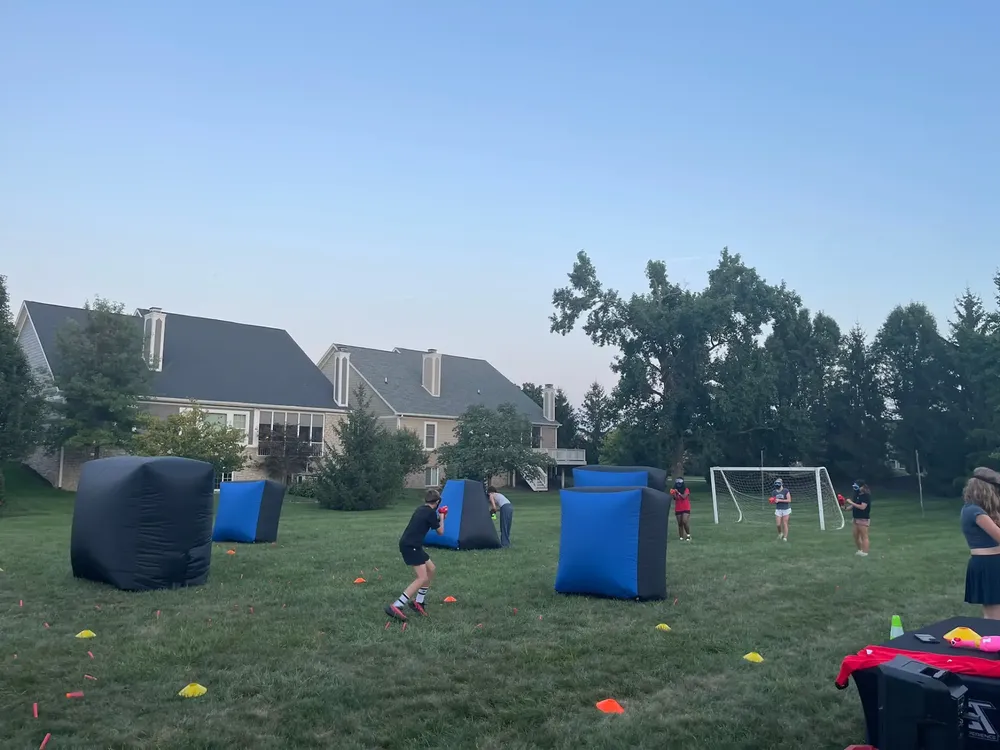 Wide backyard Nerf battlefield with color-coded inflatable bunkers