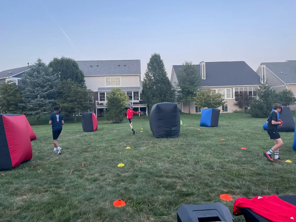 Player sprinting across the field during a mobile Nerf battle in a backyard